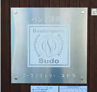 須藤氏自らデザインした、ブーランジェリー スドウの看板。皿の上に載ったバゲットがコンセプト