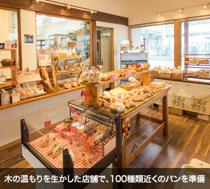 木の温もりを生かした店舗で、100種類近くのパンを準備。