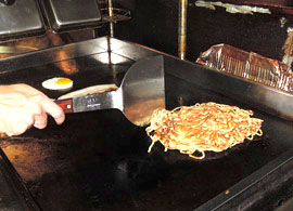 麺と、トッピングの目玉焼きとチャーシューを焼き上げる